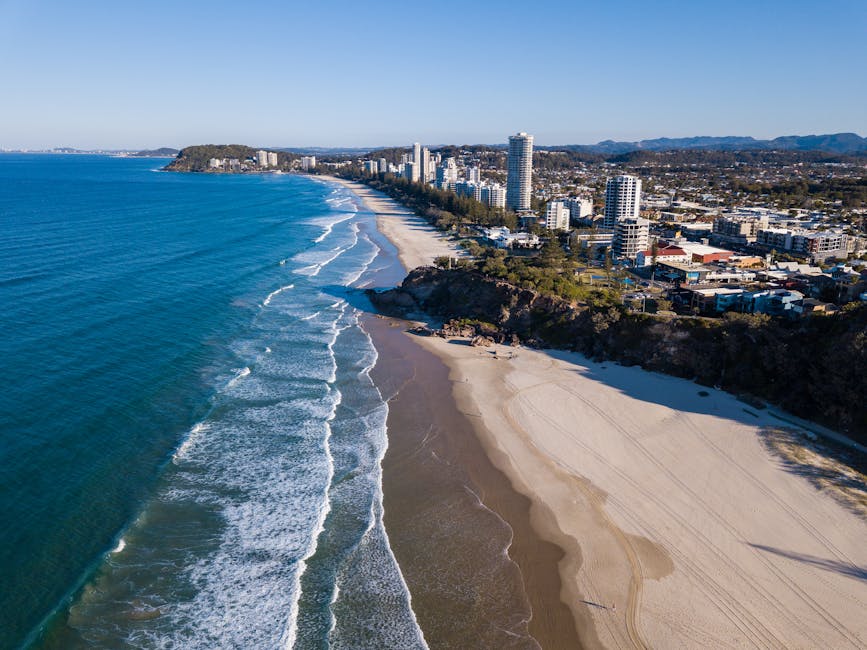Stunning aerial view of coastline with beaches, city skyline, and scenic ocean.